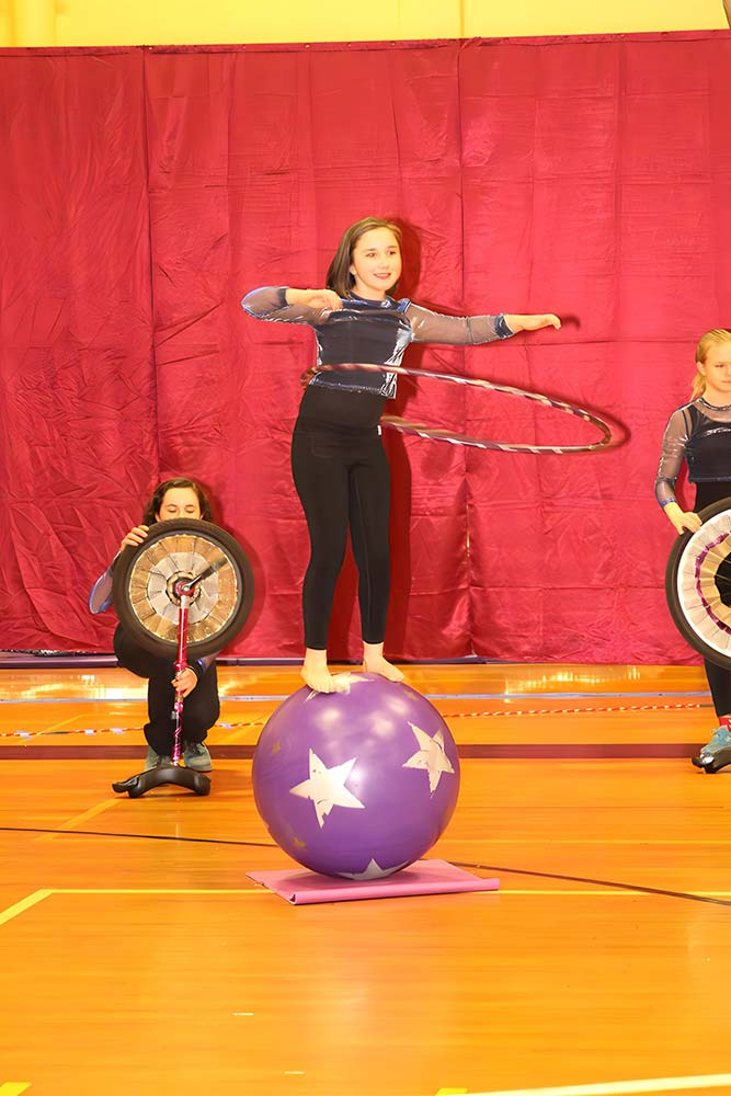 Kid hula-hooping while standing on an exercise ball at SHOW Circus Studio in Easthampton, Massachusetts