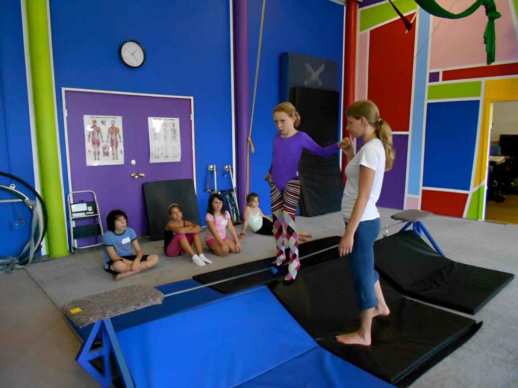 A teacher helping a kid walk on a wire at SHOW Circus Studio in Easthampton, Massachusetts