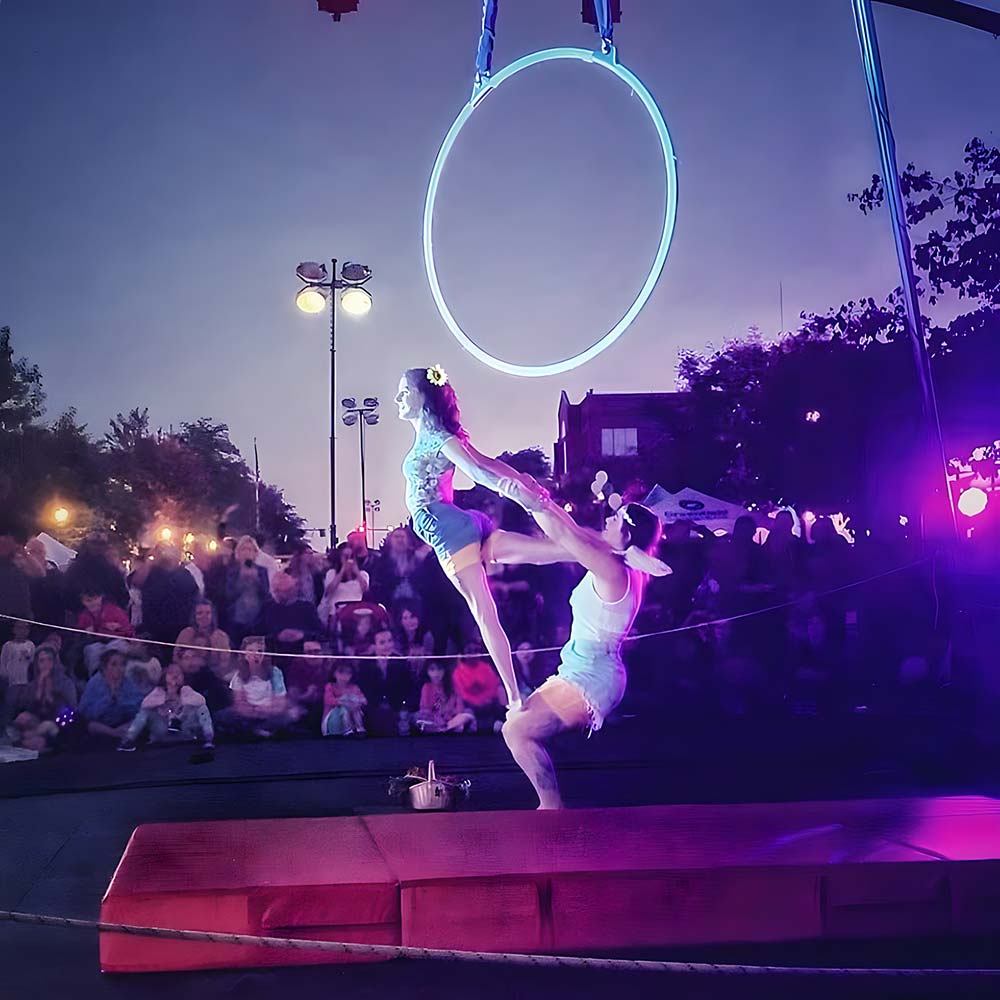 Two performers from SHOW Circus Studio in Easthampton, Massachusetts, doing a balancing act in the evening in front of a small audience.